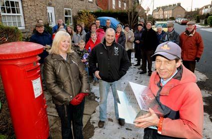 Postman Clive Atkinson receives retirement presents from Kirby Misperton sub-postmistress Amanda Haigh and her husband, Michael, when villagers gave him a surprise send-off after 28 years of deliveries in his North Yorkshire patch.
