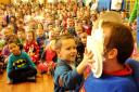 A pupil delivers a custard pie to the face of teacher John Hattam at Clifton Green Primary School.