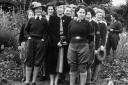 Pauline Davidson (second from right, holding her hat), pictured with other land girls and the owner of Nunnington Hall, in 1942.