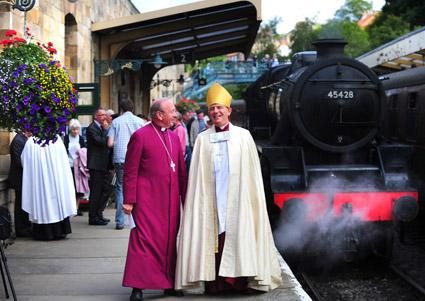 Dr David Hope, former Archbishop of York and Bishop of Wakefield, and the current Bishop of Wakefield, Stephen Platten, stroll past the steam engine following its dedication service at Pickering Station in honour of Eric Treacy, the Railway Bishop.