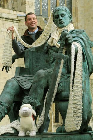 Sheep farmer Richard Findlay puts a scarf around the statue of Constantine outside York Minster, where Yorkshire farmers celebrated National Wool Week.