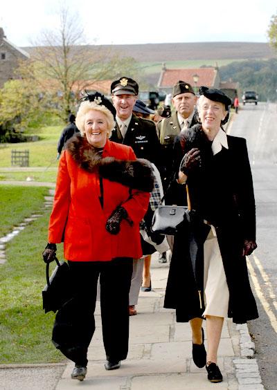 Visitors enjoy a stroll in the autumn sun in Goathland during the North Yorkshire  Moors Railway In Wartime weekend.