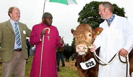 The Archbishop of York Jon Sentamu with the Acting Chairman of Malton Show, Charlie Breese, meet Edward Mackley and his bull Fabrigas which won Champion Limousin at the  show