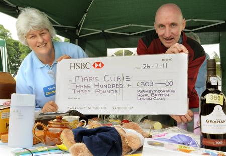 James Bell of Kirkbymoorside British Legion Club, presents a cheque to June Cook, of Marie Curie Cancer Care Kirkbymoorside Support Group, on the charity’s stand.