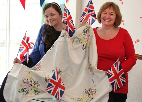 Megan and Tracy Bush of Poppy's Tea Rooms in Pickering with the tablecloth sent to them from a customer who spent 20 years embroidering the design which she bought at the time of the coronation