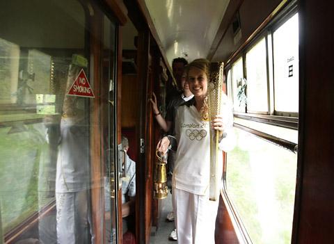 Torchbearer 049 Kelly Williams holds the Olympic Flame whilst aboard the steam locomotive The Green Knight during its journey on the North Yorkshire Moors Railway.