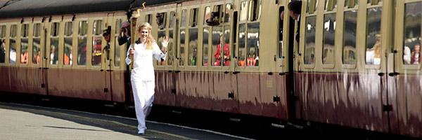 Kelly Williams carrying the Olympic Flame as she runs past railway coaches before its journey on the North Yorkshire Moors Railway, from Whitby to Pickering.