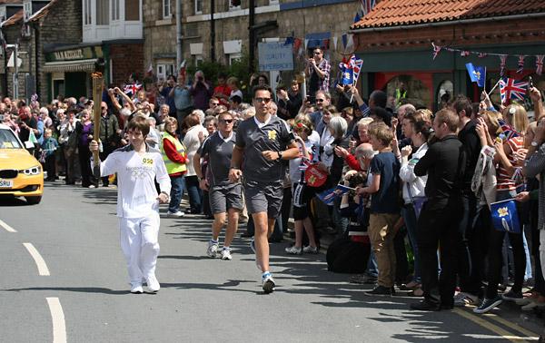 Maxwell Strachan carries the Olympic Flame