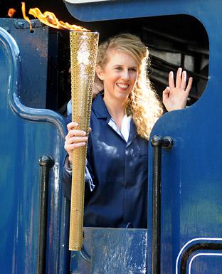 Kelly Williams carries the Olympic torch into Pickering's North Yorkshire Moors Railway station on board the Sir Nigel Gresley
