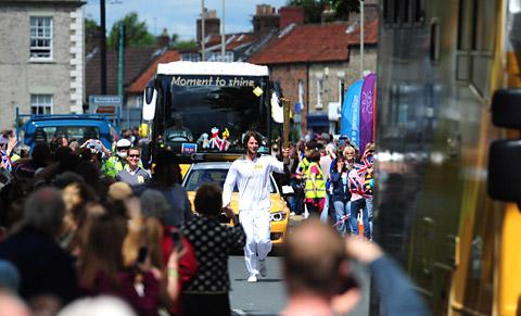Tom Ransley carries the Olympic Torch in Pickering 