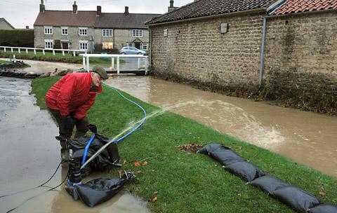 Resident  Eddie Lucas  who lives at Beckside Cottage keeps an eye on the rising floodwater at Hovingham as water is pumped away from the houses