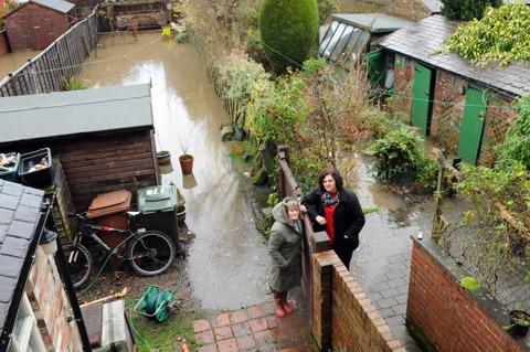 Di Keal (right) and her neighbour Glynis Gibson in the back gardens of their homes, in St Nicholas Street, Norton, which have been flooded with sewage. 
