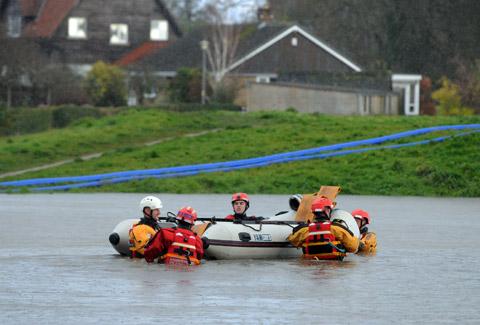 A North Yorkshire Fire and Rescue team move a boat carrying pumping equipment through floodwater at Old Malton.