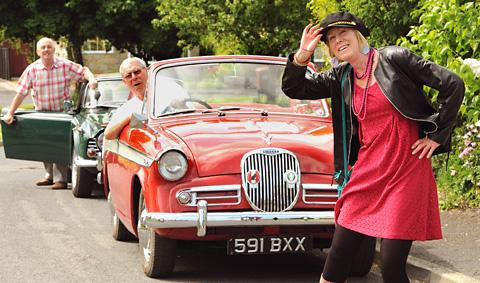 ERA: Lollipop lady Yvonne Brandon donned her 60s outfit to stop the traffic in a different way as she joined Jim Howie, left, and Bruce Pickup and their sixties cars to promote the Pickering 60s Festival.
