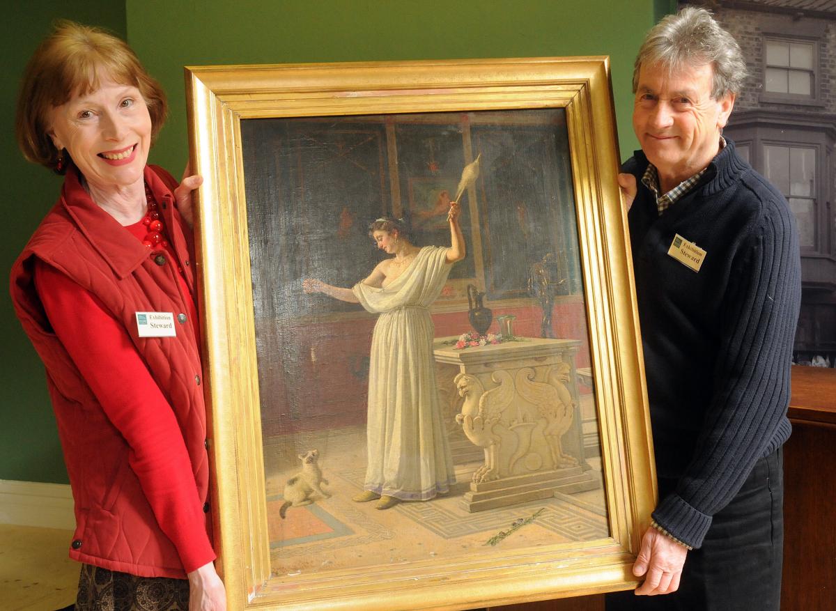 Volunteers Christine and Malcolm Barnard with a painting on display at Malton Museum which was saved from a skip.