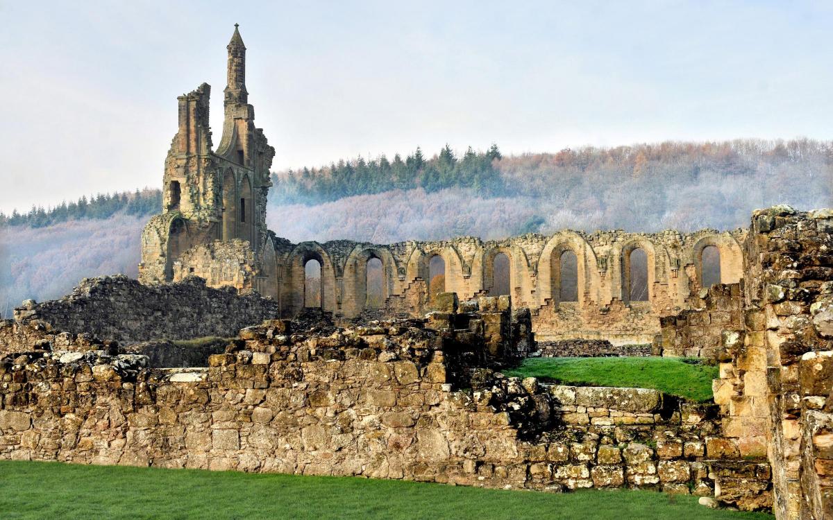 Byland Abbey nestled in the shadow of the misty Hambleton Hills.