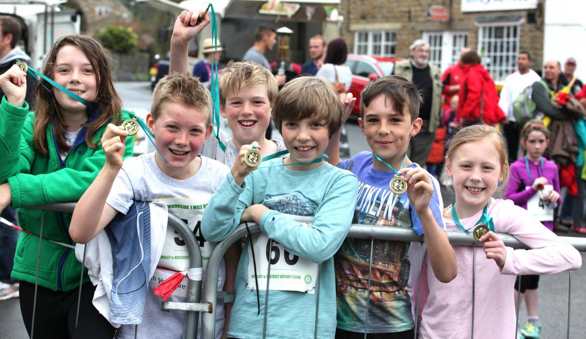 Runners, below, in the mile race show off their medals