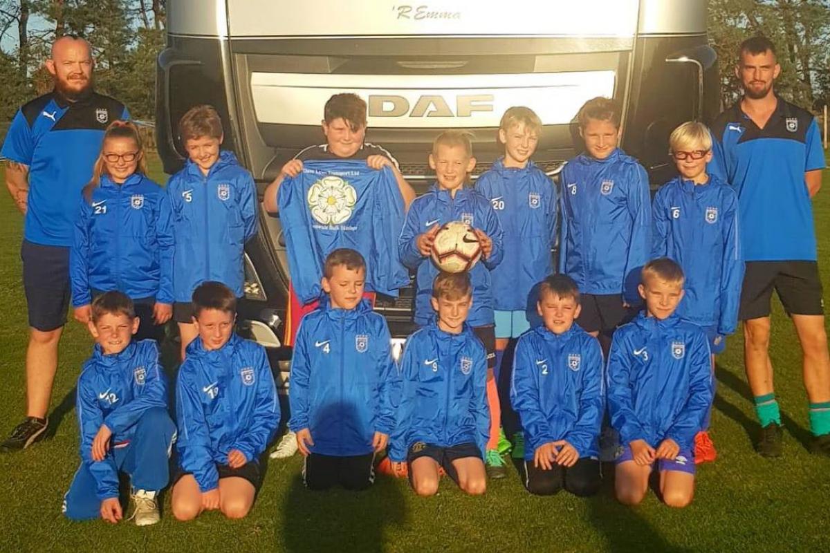 Heslerton Under-11s in their new raincoats sponsored by David Lyles Transport Ltd of Wakefield