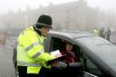 A police officer talks to a passing motorist in the village