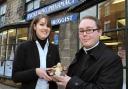 The Reverend Chris Johnson hands over baby Jesus to Helen Craggs outside Pickering Pharmacy, one of the places on the tour