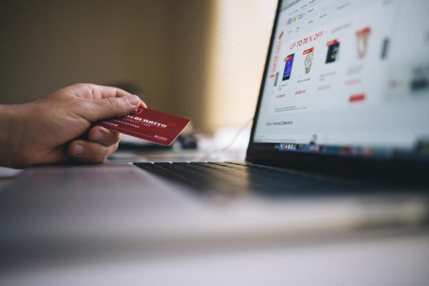 Gazette & Herald: A person holding their bank card, shopping online. Credit: Canva