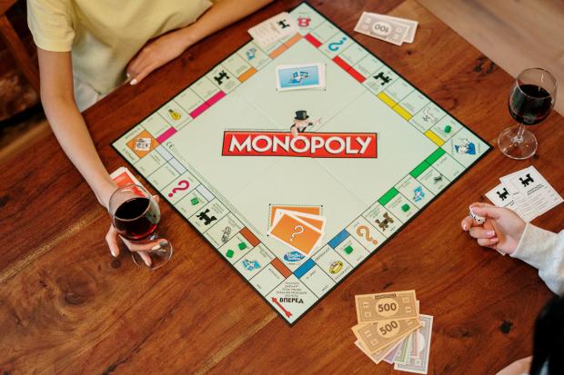 Gazette & Herald: Two people playing Monopoly (Canva)
