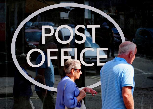 Gazette & Herald: People walking outside a Post Office. Credit: PA