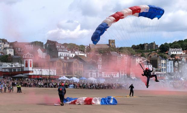 Gazette & Herald: The RAF Falcons Parachute Display Team landed on the beach in a haze of red, white and blue smoke to mark the start of the event Picture: Richard Ponter Photography/Scarborough Borough Council