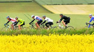 A charity cycle race through the Yorkshire Wolds weaves its way along a road through the fields near Weaverthorpe.