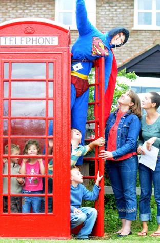 Angela Smedley and Vicky Lester with their children admire the Superman scarecrow in Foston.