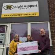 Di Tymon, Chief Officer at Sight Support Ryedale, Cathy Harland staff member, and Nick Medcalfe, Chair of Trustees with the National Lottery Cheque outside the Sight Support Ryedale office in Norton