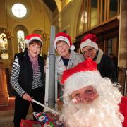 Father Christmas at St Michael’s Church getting ready  for Saturday’s fair with Barbara Hall, Romey Willis and Olive Pool