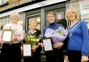 Age UK volunteers, from the left, Elenor Hepburn,
Margaret Roberts and Judith Brisby receive certificates and
flowers from town mayor Coun Chris Dowie to thank them for their
long service.
