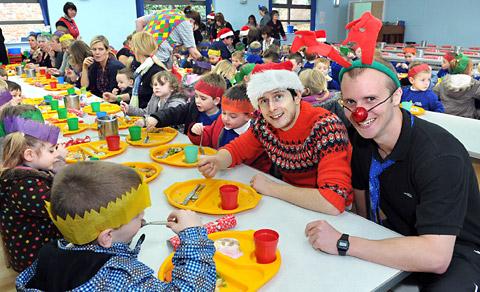 Teachers Tim Hodge, left, and Tom Myers join pupils at Norton Primary School as they enjoy their first Christmas dinner cooked on the premises for three years.