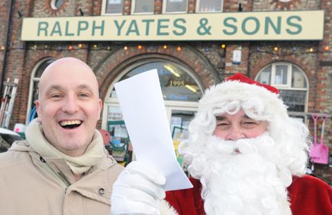 Adrian Watson, committee member of the Malton Hospital
League of Friends, receives a cheque from Father Christmas
